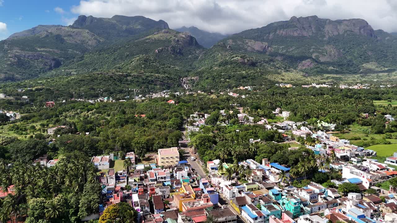 Breathtaking drone shot of Courtallam, Tamil Nadu — where misty mountains, green forests, and waterfalls create a serene blend of nature and town life