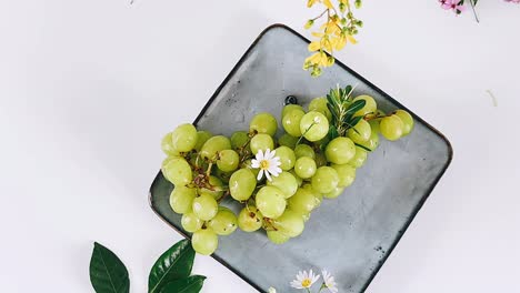 fresh green grapes on a plate with flowers