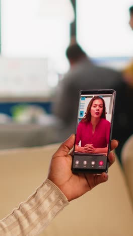 vertical video back view of african woman discussing with remote manager on video call