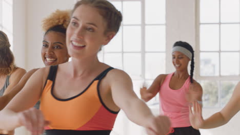 Grupo-De-Clase-De-Baile-De-Hermosas-Mujeres-Bailando-Disfrutando-Del-Entrenamiento-Practicando-Movimientos-De-Coreografía-Con-Un-Instructor-En-El-Gimnasio