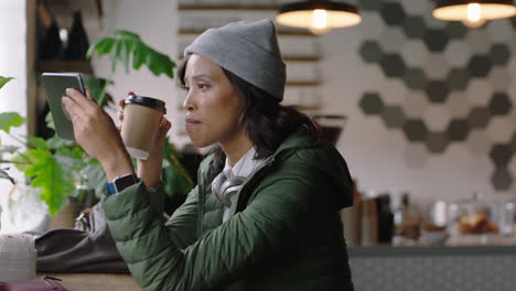 young african american woman using tablet computer in cafe watching online entertainment reading social media messages enjoying drinking coffee relaxing in trendy restuarant