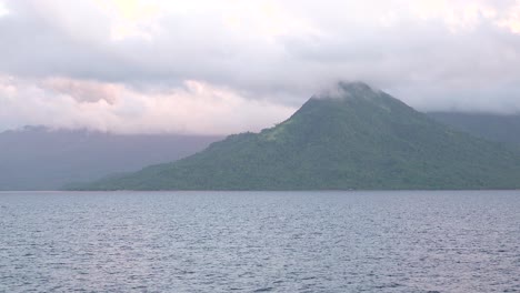 clouds passing over a beautiful exotic tropical volcanic island mountain tops in the early morning 4k