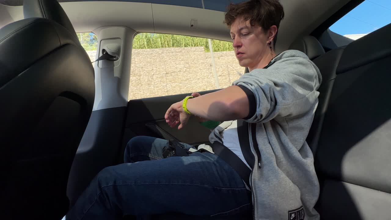 Person sitting in the back seat of a Tesla