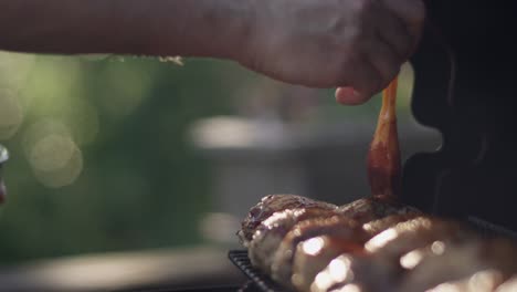 dad brushes plenty of bbq sauce on the grilled chicken