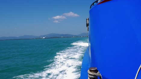 shot of blue ship moving through the sea from ship's broadside point of view