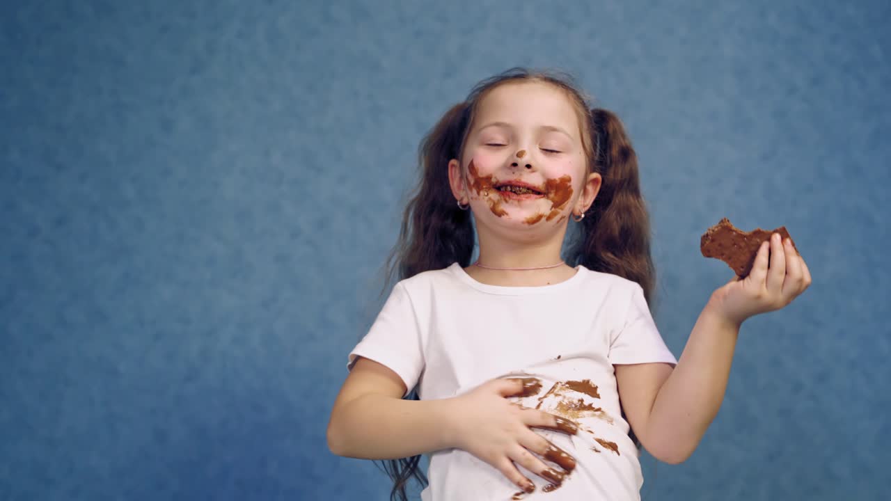 Happy girl eating chocolate. Portrait of happy girl eating chocolate bar and looking at camera