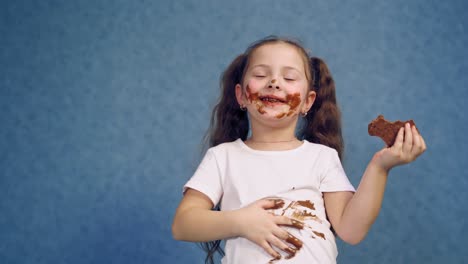happy girl eating chocolate. portrait of happy girl eating chocolate bar and looking at camera