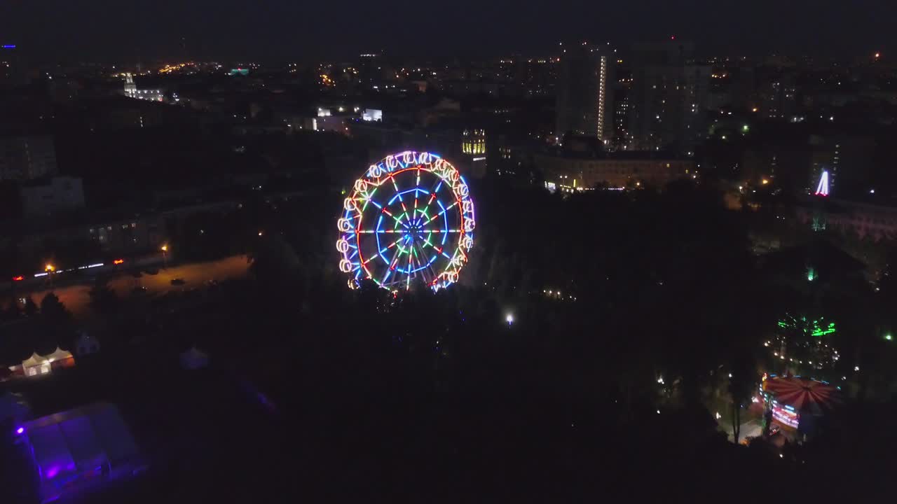 paisaje urbano por la noche con la rueda de la ferris iluminada