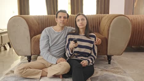 indian couple watching tv and discussing something