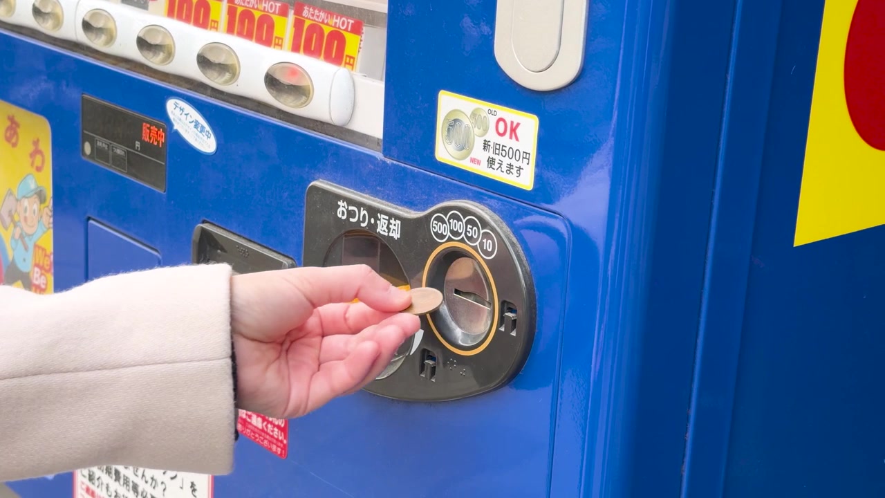 Người bỏ tiền xu vào máy bán hàng tự động Nhật Bản