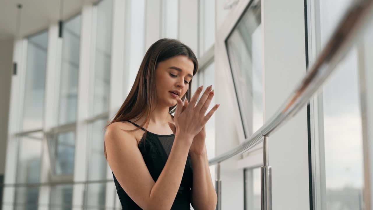 linda chica joven se abraza sentada en la cama junto a la ventana