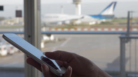 Mujer-Enviando-Mensajes-De-Texto-En-El-Móvil-En-El-Aeropuerto