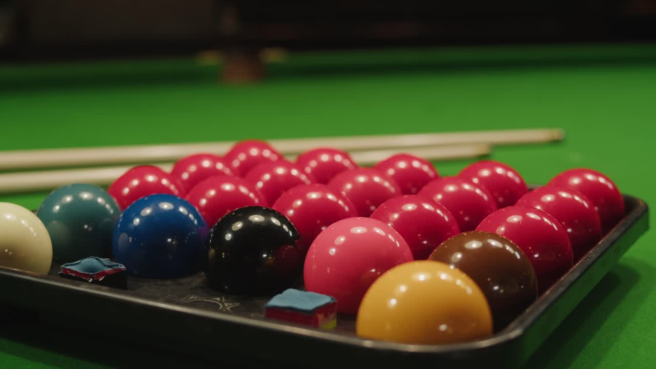 Snooker colorful balls close-up on green billiards table for start to play. Snooker game. Billiard balls with numbers on a pool table. Billiards team sport.High quality 4k footage