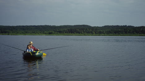 aerial view of grandfather and grandson floating on the boat on the picturesque river on a summer day