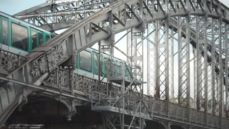 Closeup-green-and-white-aerial-metro-crossing-a-steel-bridge-over-the-Seine