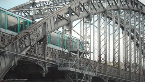 Primer-Plano-De-Metro-Aéreo-Verde-Y-Blanco-Cruzando-Un-Puente-De-Acero-Sobre-El-Sena