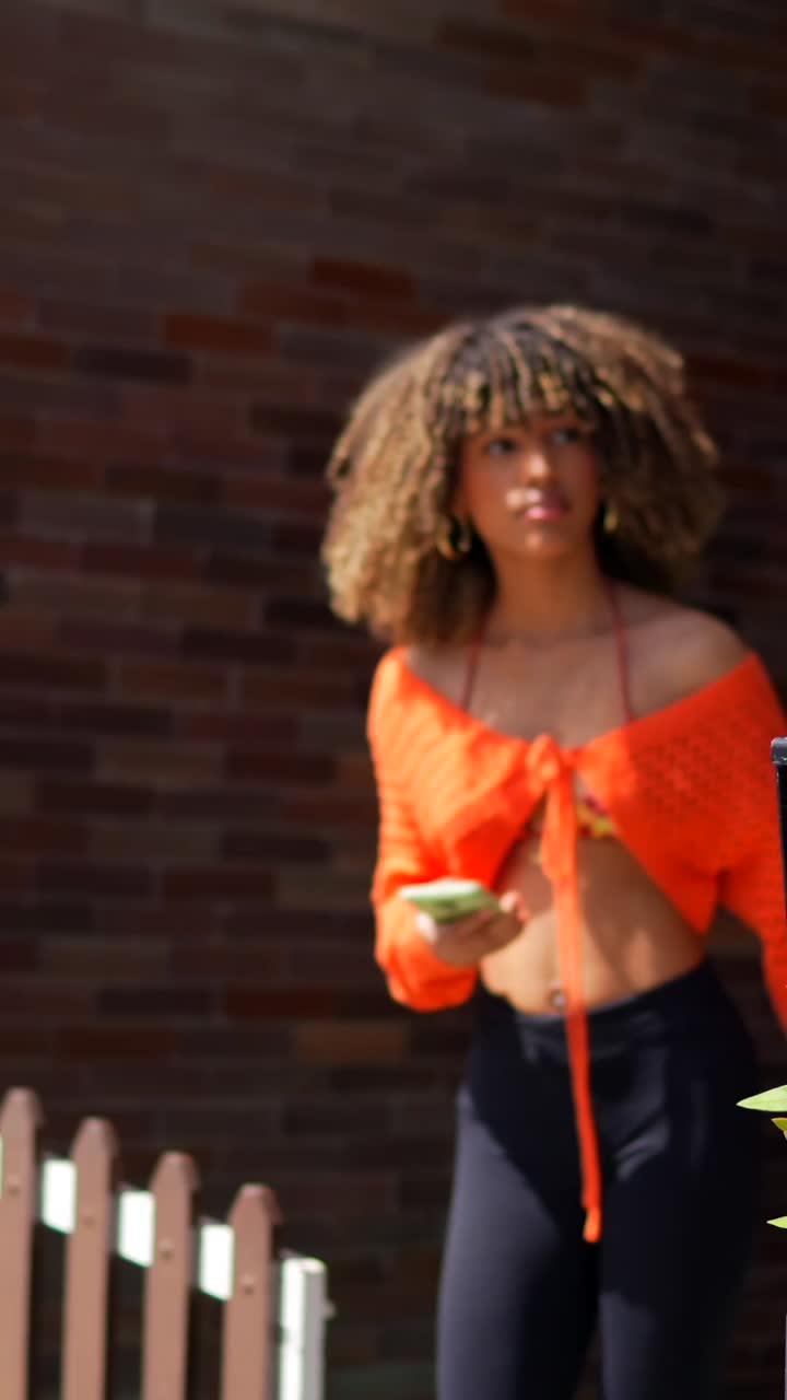 A woman with curly hair holding a smartphone