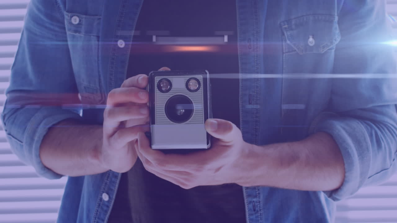 rastros de luz contra la sección media del fotógrafo masculino que sostiene una cámara retro