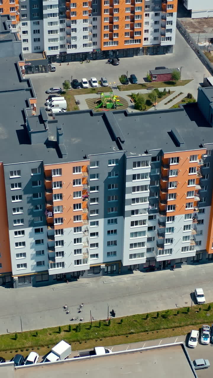 New modern apartment building. Multi-storey architecture in the city. New urban housing. Residential block of flats. Aerial view. Top down. Vertical video