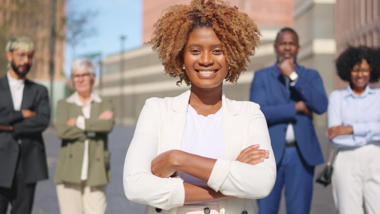 Imprenditrice africana sorridente all'aperto a braccia conserte