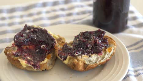 pan en cámara lenta sobre bollos cruzados calientes sentados en un plato con mantequilla espesa y mermelada durante la pascua