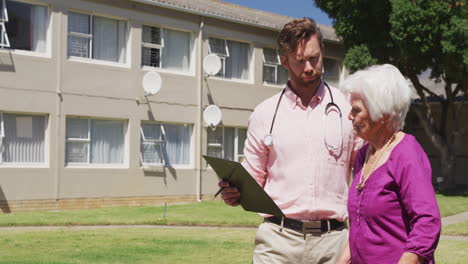 Doctor-walking-with-a-senior-woman-in-the-park-of-a-retirement-home