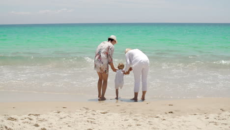 Kleines-Mädchen-Spielt-Mit-Ihrer-Familie-Am-Meer