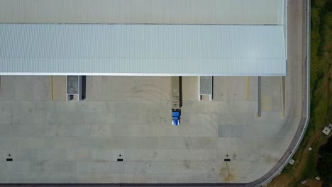 Aerial-Shot-Of-Single-Blue-Lorry-Truck-Parked-In-Huge-Warehouse-Depot