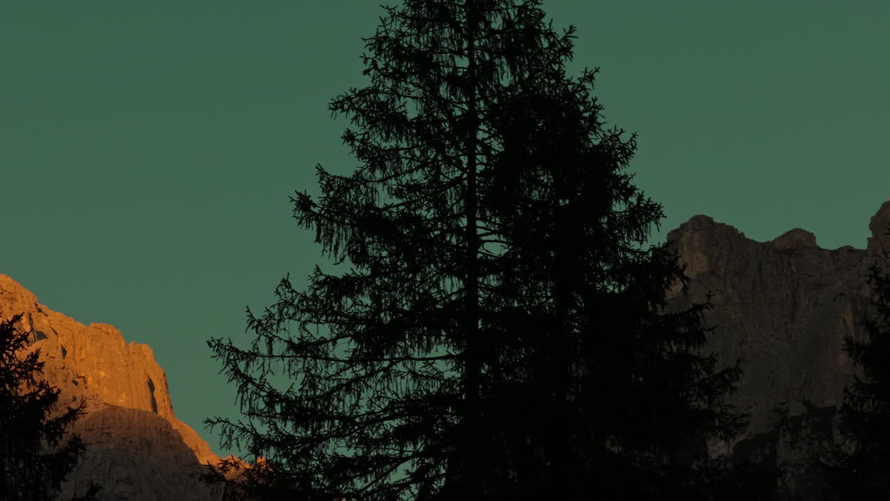 Sunrise or Sunset over Rocky Mountain Peaks with Pine Trees