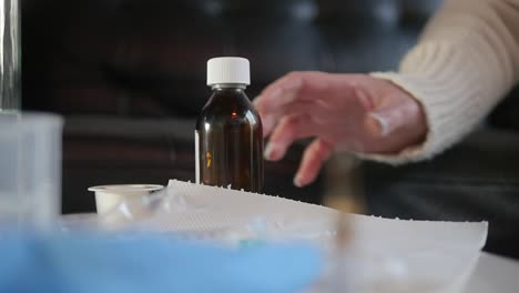 primer plano de poner una botella de medicina sobre la mesa