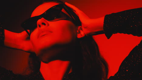 mujer en luz roja con gafas de sol