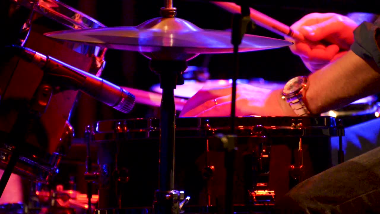 Batterista jazz a un concerto, scena teatrale, batteria, video, telecamera in movimento, primo piano.
