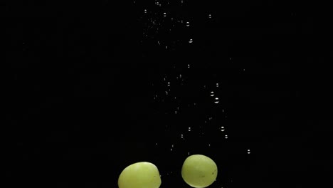 fast drowning grapes with air bubbles isolated on black background