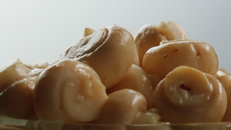 fermented champignons, jar with marinated mushrooms on wooden table, traditional salted marinated asian food.