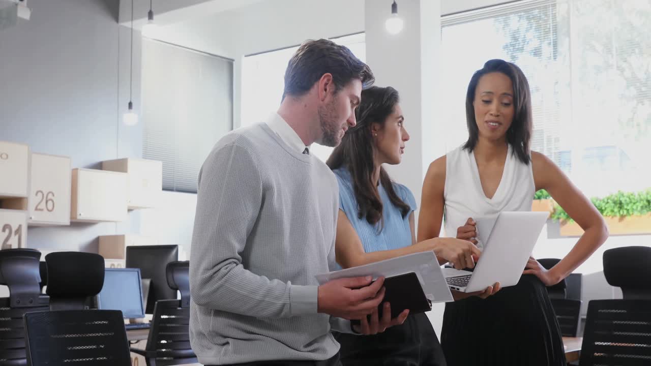 colegas de negocios discutiendo sobre una computadora portátil 4k