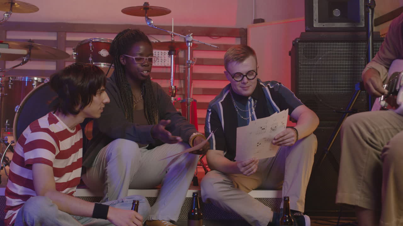 다민족 음악 밴드가 녹음실에서 리허설을 하면서 함께 노래를 토론한다