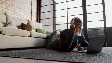 Senior-man-listening-music-on-laptop-in-living-room-4k