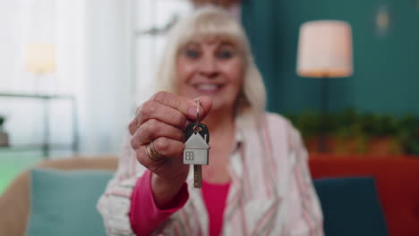 Senior-old-woman-customer-landlord-hold-key-to-new-house-real-estate-owner-make-sale-rental-purchase