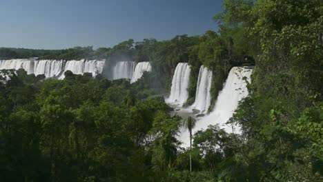 Erstaunliche-Gruppe-Von-Wasserfällen,-Die-Bei-Wunderschönen-Sonnigen-Bedingungen-In-Den-Iguazu-Wasserfällen,-Argentinien,-Von-Riesigen-Klippen-Fallen,-Dramatische-Fernsicht-Auf-Wunderschöne-Wasserfälle-In-Einer-Malerischen-Grünen-Dschungellandschaft