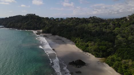 drone view flying over the coast before making a panoramic shot of the sand, costa rica
