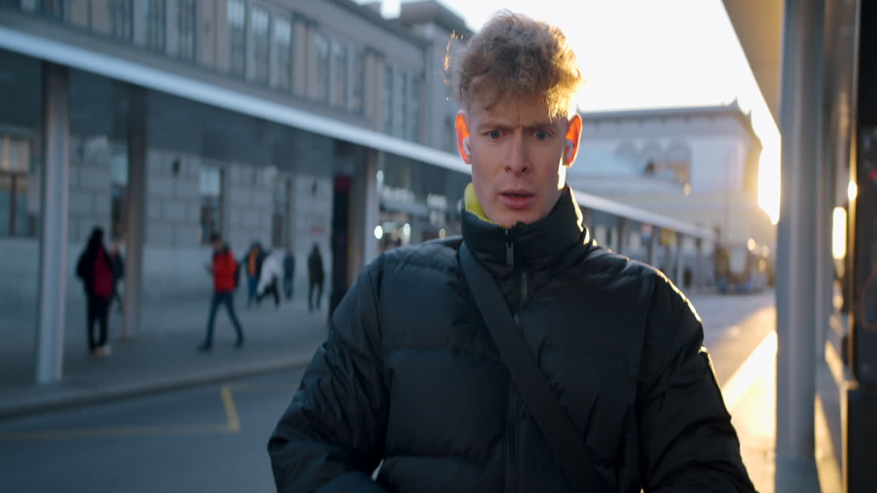 Young Man Pointing at Bus Stop