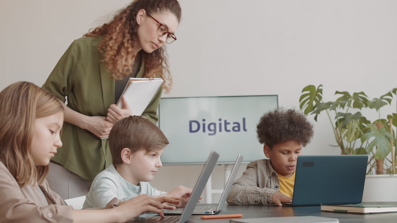 Woman Teaching IT to Diverse Children