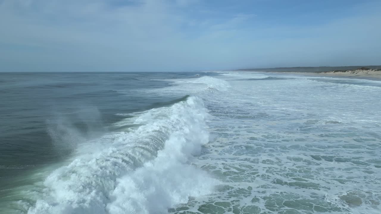 volando sobre el océano con olas rompientes en nazare, portugal