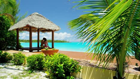 caucasian couple sitting in a tiki beach hut