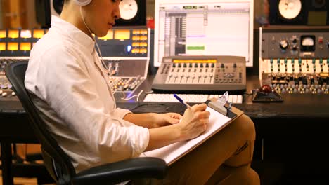 ingenieros de audio masculinos escribiendo en el clipboard