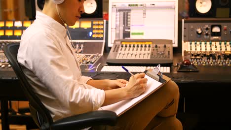 male audio engineers writing on clipboard