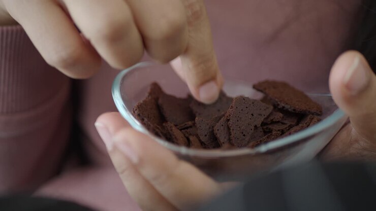 Persona che si gusta una ciotola di gocce di cioccolato