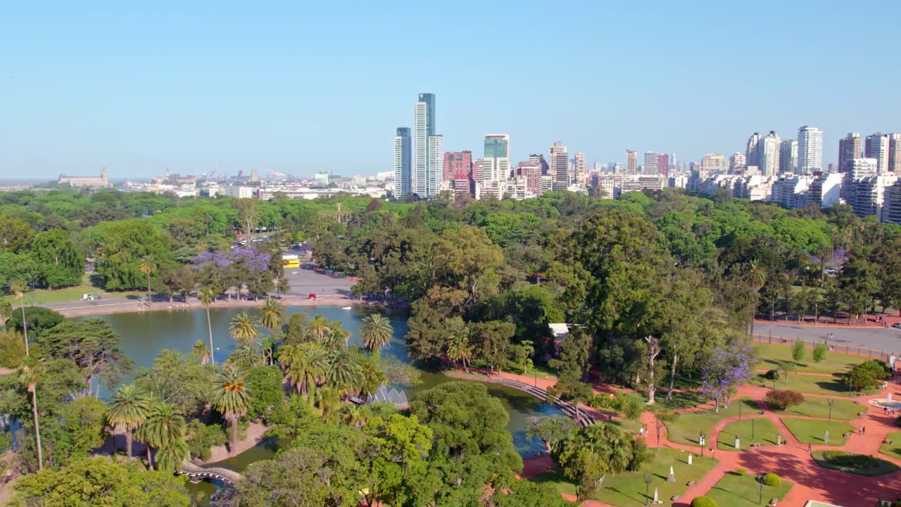 dolly en vista aérea del contraste entre el jardín de rosas de palermo y los nuevos edificios residenciales de buenos aires en el fondo, soleado día de primavera