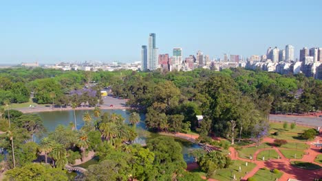 Dolly-En-Vista-Aérea-Del-Contraste-Entre-El-Jardín-De-Rosas-De-Palermo-Y-Los-Nuevos-Edificios-Residenciales-De-Buenos-Aires-En-El-Fondo,-Soleado-Día-De-Primavera