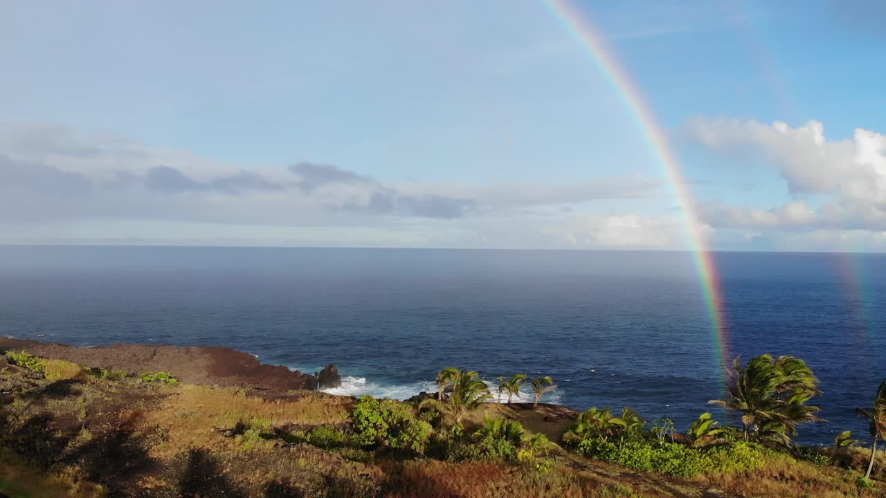 levantándose frente a dos arco iris sobre el océano pacífico